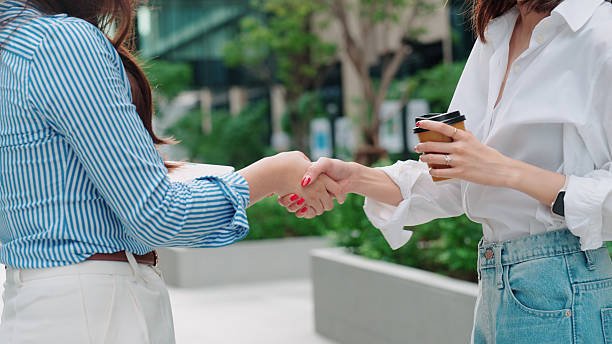 two professional women shaking hands to confirm a business partnership.